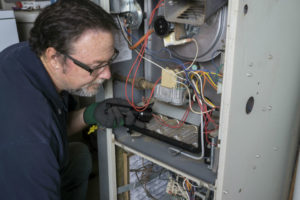 man repairing gas furnace