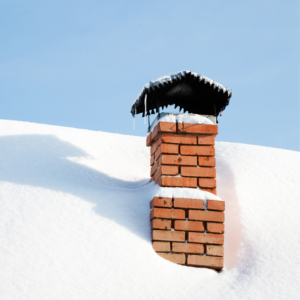 a masonry chimney covered in snow with a blue sky in the background