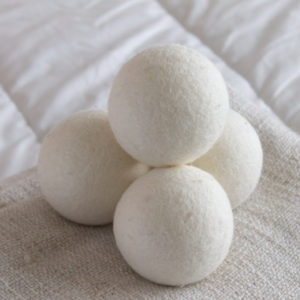 dryer balls stacked on a bed in the shape of a pyramid